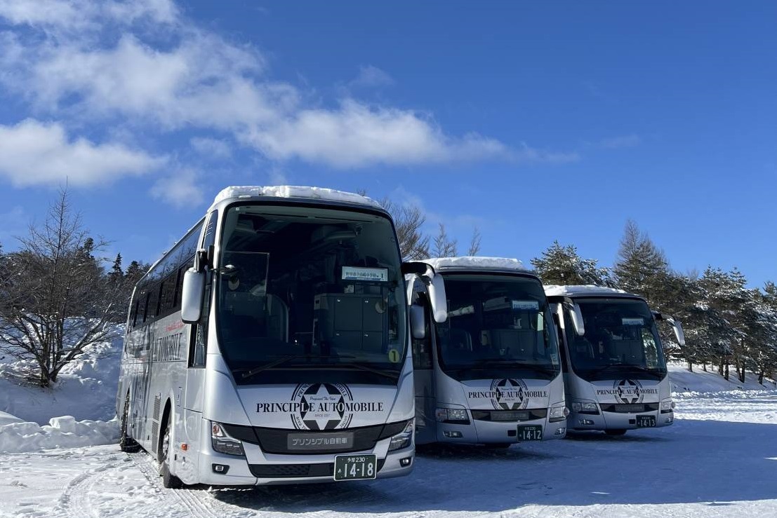 雪山に並ぶプリンシプル自動車の貸切バス